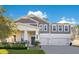 Two-story home with gray siding, white trim, and a three-car garage at 11120 Robert Frost Dr, Winter Garden, FL 34787