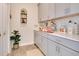 Bright laundry room with gray cabinets and quartz countertops at 11120 Robert Frost Dr, Winter Garden, FL 34787