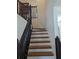 Wooden staircase with black railings leading to the upper level at 1424 Sophie Way, Kissimmee, FL 34744