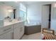 Bathroom features a soaking tub and white cabinets at 16548 Raven Rock Pl, Winter Garden, FL 34787