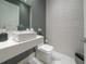 Elegant powder room with white fixtures and textured wall at 16548 Raven Rock Pl, Winter Garden, FL 34787