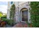 Dark brown double-door entry with stone archway and landscaping at 16548 Raven Rock Pl, Winter Garden, FL 34787