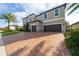 Two-story house with gray exterior, stone accents, and a two-car garage at 16548 Raven Rock Pl, Winter Garden, FL 34787