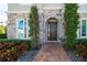 Dark brown double-door entry with stone archway and landscaping at 16548 Raven Rock Pl, Winter Garden, FL 34787