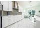 Modern kitchen featuring white cabinets, marble floors and stainless steel appliances at 16548 Raven Rock Pl, Winter Garden, FL 34787