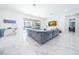 Open concept living room with grey sectional sofa and pool view at 16548 Raven Rock Pl, Winter Garden, FL 34787