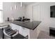 Modern wet bar with black countertop and seating at 16548 Raven Rock Pl, Winter Garden, FL 34787