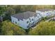 Aerial view of modern townhouses with gray roofs and white exterior, surrounded by lush green trees at 17354 Blessing Dr, Clermont, FL 34714