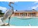 Community pool and spa with solar panels and metal heron sculpture at 17354 Blessing Dr, Clermont, FL 34714