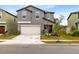 Two-story house with gray siding, beige garage door, and small front yard at 1791 Yellow Trl, Lakeland, FL 33801