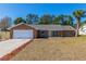 Brick ranch house with a white door, two-car garage, and landscaped lawn at 2008 Dixie Belle Ave, Deltona, FL 32725