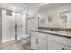 Modern bathroom with a glass-enclosed shower, vanity with a large mirror, and neutral tile flooring at 2186 Fleming Mist Pl, Kissimmee, FL 34747