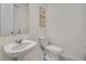 Cozy powder room with pedestal sink, modern toilet, and decorative wall art at 2186 Fleming Mist Pl, Kissimmee, FL 34747