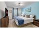 Comfortable bedroom featuring a queen bed, stylish lighting, and calming blue accent wall at 2186 Fleming Mist Pl, Kissimmee, FL 34747