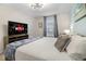 Comfortable bedroom featuring a queen bed, stylish lighting, and flat screen television at 2186 Fleming Mist Pl, Kissimmee, FL 34747