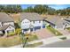 Two-story house with gray exterior, blue garage doors, and landscaped yard at 2230 Standing Rock Cir, Oakland, FL 34787