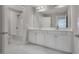 Main bathroom with double sinks, white cabinets, and a large mirror at 2230 Standing Rock Cir, Oakland, FL 34787
