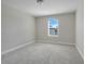 Simple bedroom with gray carpet and a window at 2230 Standing Rock Cir, Oakland, FL 34787