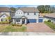 Two-story house with gray exterior, blue garage doors, and landscaped yard at 2230 Standing Rock Cir, Oakland, FL 34787