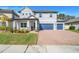 Two-story house with gray exterior, blue garage doors, and landscaped yard at 2230 Standing Rock Cir, Oakland, FL 34787