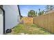 Backyard with wooden fence and gate providing privacy, featuring an air conditioning unit, and green grass at 2417 Liela Lee Ct, Ocoee, FL 34761