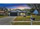 Charming home featuring a dark garage door, lush landscaping, and inviting curb appeal at 2417 Liela Lee Ct, Ocoee, FL 34761