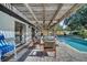Spacious covered patio with brick pavers, chandelier and poolside dining furniture overlooking the pool at 2417 Liela Lee Ct, Ocoee, FL 34761