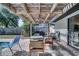 Covered patio with brick pavers, pergola, chandelier and poolside dining furniture at 2417 Liela Lee Ct, Ocoee, FL 34761