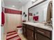 Clean bathroom with dark vanity and red and white decor at 264 Citrus Pointe Dr, Haines City, FL 33844