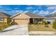 Charming single Gathering home featuring a two-car garage and landscaped front yard with a well-manicured lawn at 264 Citrus Pointe Dr, Haines City, FL 33844