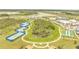 Wide aerial shot showcasing community tennis courts, bocce ball, town center and the surrounding landscape at 306 Hang Loose Way, Daytona Beach, FL 32124