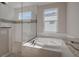 Bright bathroom with soaking tub and glass enclosed shower with granite counters and white cabinetry at 306 Hang Loose Way, Daytona Beach, FL 32124