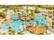 Beautiful community pool featuring tiki huts, palm trees, a bridge, and lounge chairs at 306 Hang Loose Way, Daytona Beach, FL 32124