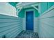 Beautiful front entrance with a blue door, brick walkway, and turquoise blue siding at 306 Hang Loose Way, Daytona Beach, FL 32124
