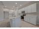 Kitchen featuring white cabinetry, stainless steel appliances, granite countertops and large island with a sink at 306 Hang Loose Way, Daytona Beach, FL 32124