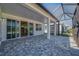 Covered patio with brick pavers and view into the kitchen through sliding glass doors at 306 Hang Loose Way, Daytona Beach, FL 32124