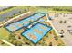 Aerial view of well-maintained, blue-surfaced pickleball courts with surrounding greenery and parking at 306 Hang Loose Way, Daytona Beach, FL 32124