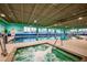 Indoor pool area featuring hot tub, lap lanes, and handicap access lift at 306 Hang Loose Way, Daytona Beach, FL 32124
