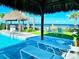 Relaxing poolside view with palm trees, lounge chairs, and a glimpse of the ocean at 306 Hang Loose Way, Daytona Beach, FL 32124