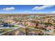 Expansive aerial view of a suburban neighborhood featuring well-maintained homes and lush greenery under a bright blue sky at 3841 Golden Knot Dr, Kissimmee, FL 34746