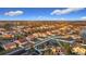 An aerial shot captures a sprawling community with neatly arranged homes, green spaces, and a tranquil lake in the distance at 3841 Golden Knot Dr, Kissimmee, FL 34746