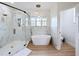 Modern bathroom with a walk-in glass shower, a soaking tub, and modern finishes at 3841 Golden Knot Dr, Kissimmee, FL 34746