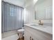 Bright bathroom featuring a modern vanity with gold accents, decorative mirror and a tub at 3841 Golden Knot Dr, Kissimmee, FL 34746