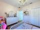 Pink themed bedroom featuring a charming chandelier, a white dresser and shelving at 3841 Golden Knot Dr, Kissimmee, FL 34746