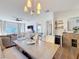 Bright dining area featuring a modern chandelier and elegant table setting, adjacent to a cozy living space at 3841 Golden Knot Dr, Kissimmee, FL 34746