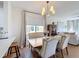 Bright dining area features elegant seating, a stylish chandelier, and natural light from a large window at 3841 Golden Knot Dr, Kissimmee, FL 34746
