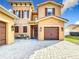 Home exterior showing attractive garage doors, brick paver driveway and front entrance at 3841 Golden Knot Dr, Kissimmee, FL 34746