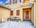 Charming front courtyard with pavers, seating and covered entrance with stylish front door at 3841 Golden Knot Dr, Kissimmee, FL 34746