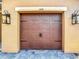 Close up of a garage door with carriage style hardware and decorative lanterns at 3841 Golden Knot Dr, Kissimmee, FL 34746