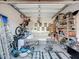 Cluttered garage featuring a lawn mower, couch, bicycle and shelf units at 3841 Golden Knot Dr, Kissimmee, FL 34746